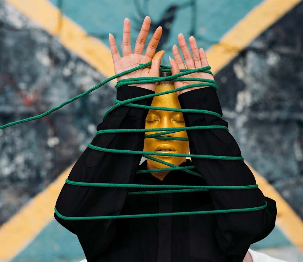 Jamaican portrait framed by green rope and a painted island road